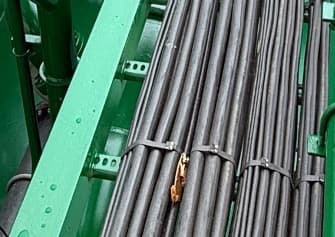 Welded angle tray on a ship deck, cables strapped across its rungs